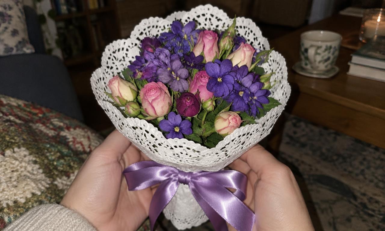 Un bouquet rond serré, emballé d'une dentelle de papier et fermé d'un ruban.